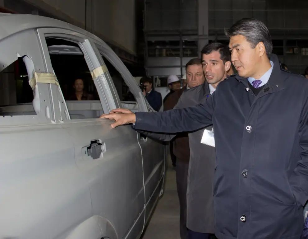 Президент ГК AllurAuto Андрей Лаврентьев демонстрирует Асету Исекешеву корпус нового автомобиля.