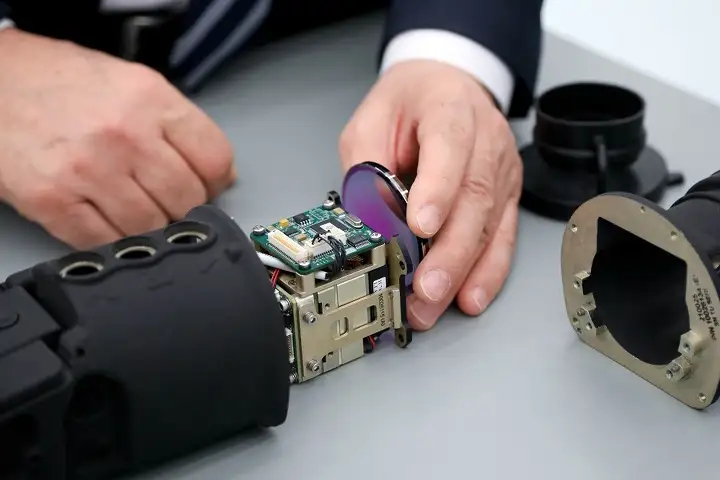 Электроннооптический прибор, который состоит в том числе из произведенных на заводе линз (в левой руке) и платы