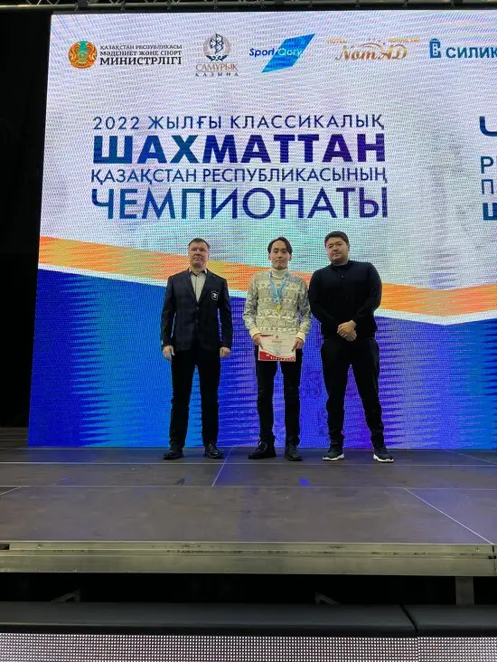 Счастливого победителя Рамазана Жалмаханова награждали гроссмейстер Павел Коцур, главный тренер КШФ (слева), и международный мастер Даулет Дускужанов, представитель одного из спонсоров чемпионата (справа)