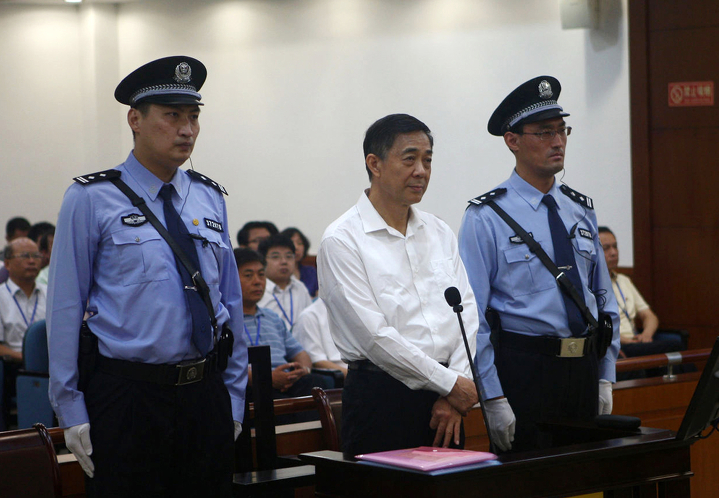 Бо Силай (в центре) - бывший глава Коммунистической партии Китая в муниципалитете Чунцин - стоит во время открытого судебного разбирательства по обвинению его во взяточничестве и злоупотреблении властью