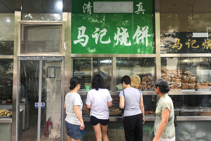 Арабская надпись заклеена на вывеске магазина халяльной еды в районе Нюцзе в Пекине, Китай. Снимок сделан 19 июля 2019