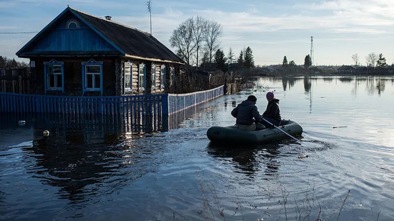 Паводки в Казахстане в 2024 году - люди спасаются на лодке в затопленной местности