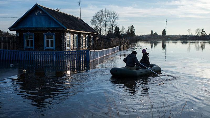 Паводки в Казахстане в 2024 году - люди спасаются на лодке в затопленной местности