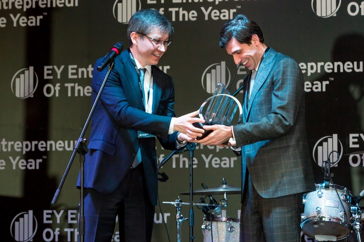 Управляющий партнер EY Ерлан Досымбеков вручает награду национальному победителю конкурса 2014 года Андрею Лаврентьеву 