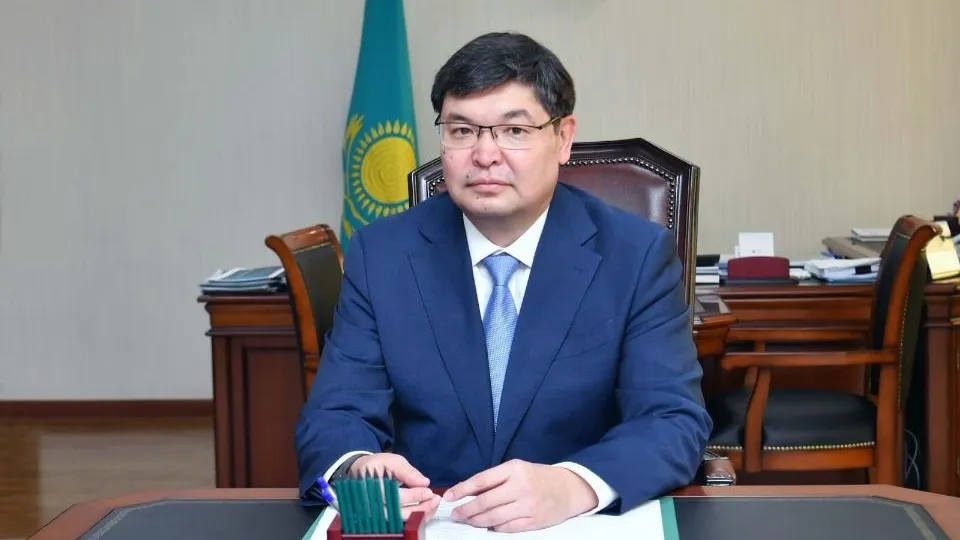 Мади Такиев, министр финансов, мужчина сидит за столом, чиновник в очках