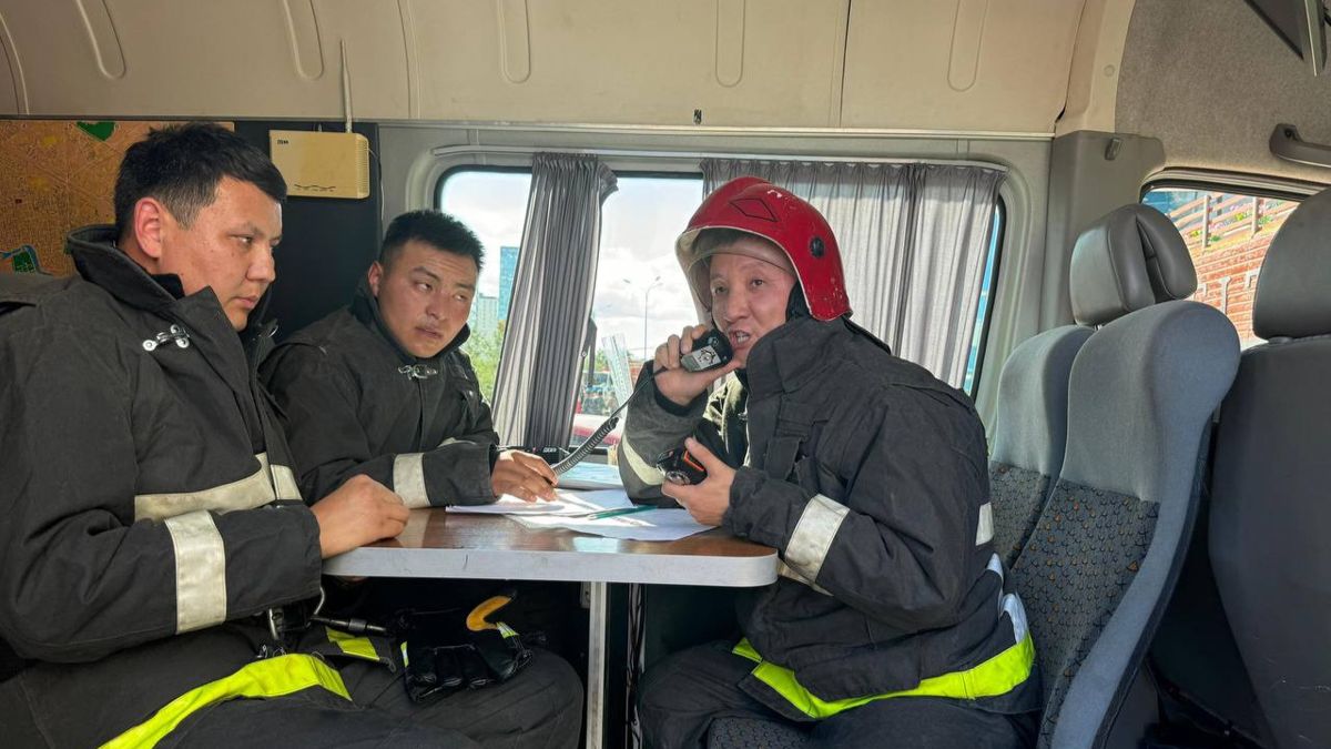 Пожарные внутри служебной машины во время пожара в ЖК возле ТРЦ «Хан-Шатыр» в Астане, 22 июня 2024 года