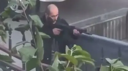 Мужчина с бородой целится из оружия