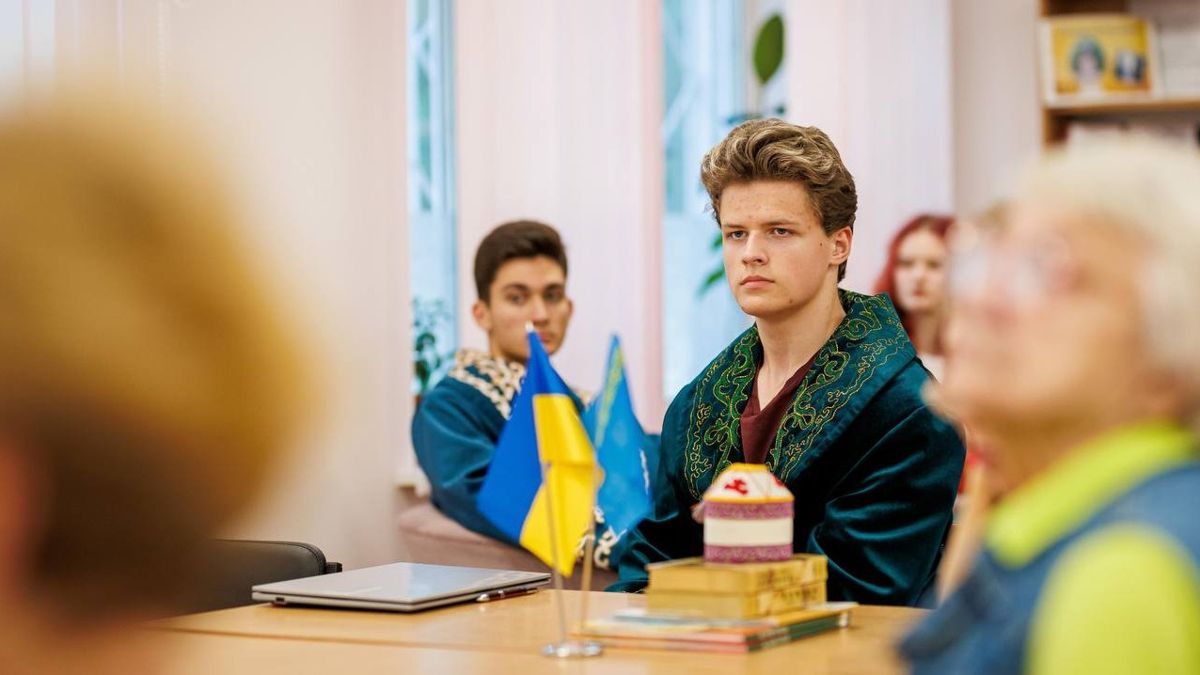 Ученики украинской школы в казахских национальных костюмах Ученики украинской школы в казахских национальных костюмах сидят за столом с флагами Украины и Казахстана