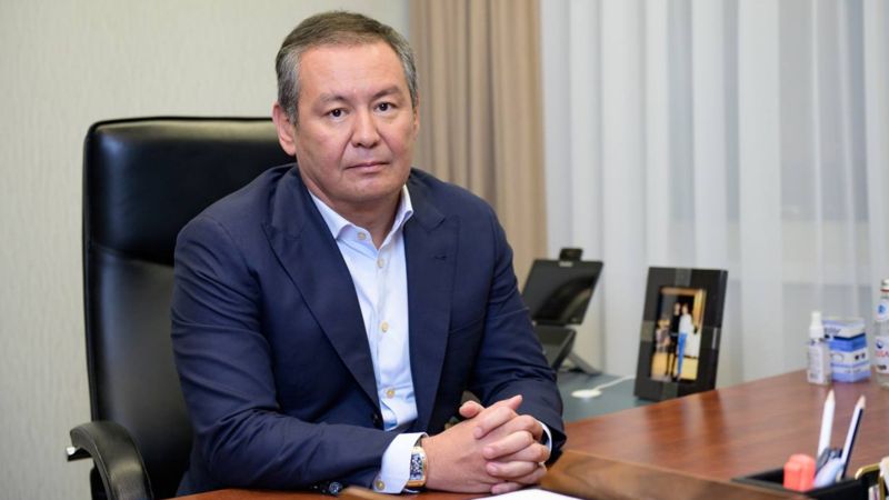 Данияр Абулгазин сидит в кресле за столом