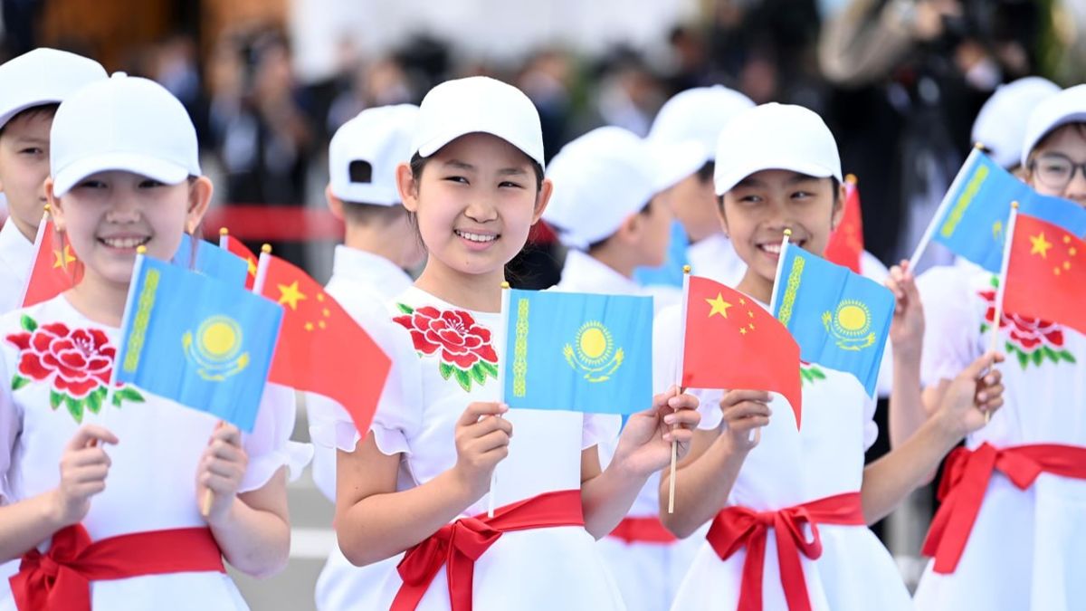 Си Цзиньпина встречают дети с флажками двух стран, девочки в белых бесйсболках