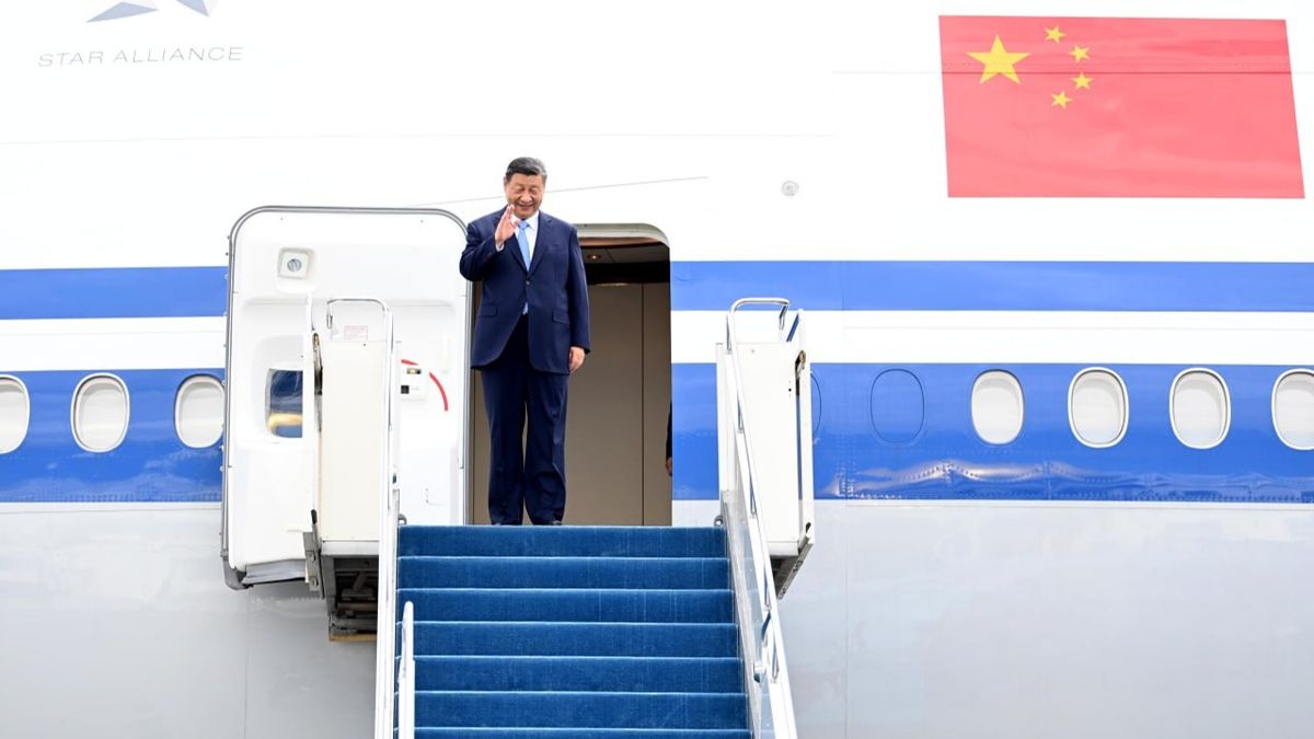 Си Цзиньпин стоит на трапе самолета в Астане