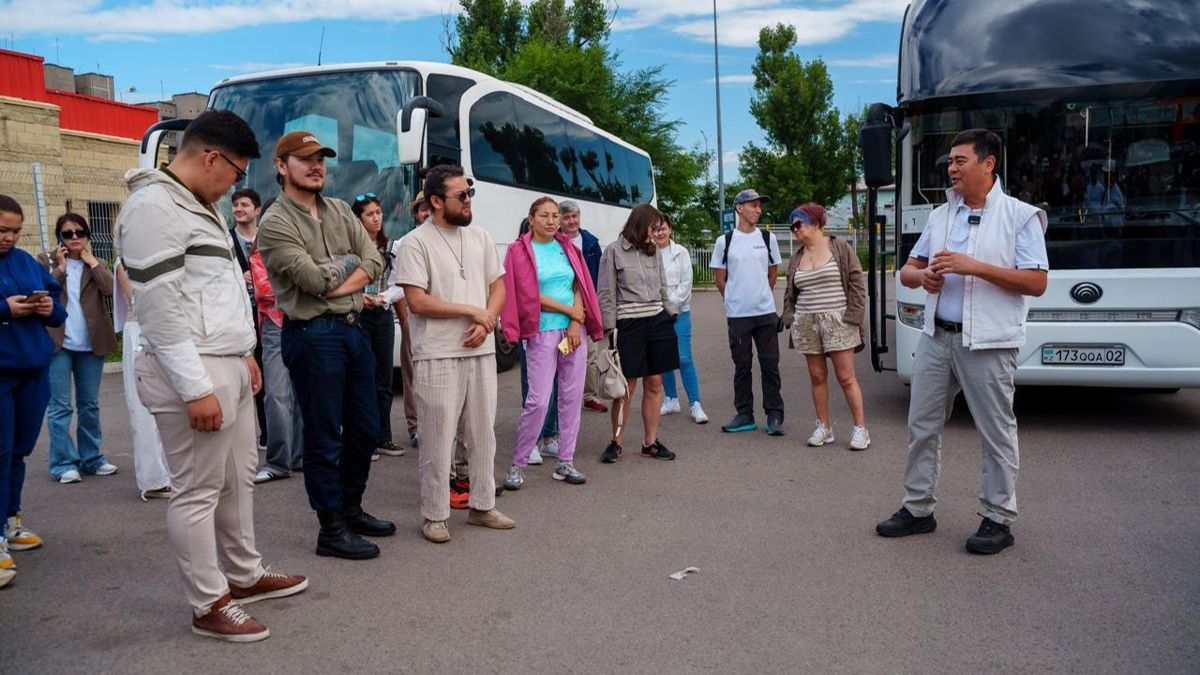Арманжан Байтасов (справа) знакомит участников тура на Танбалы с программой у автобуса