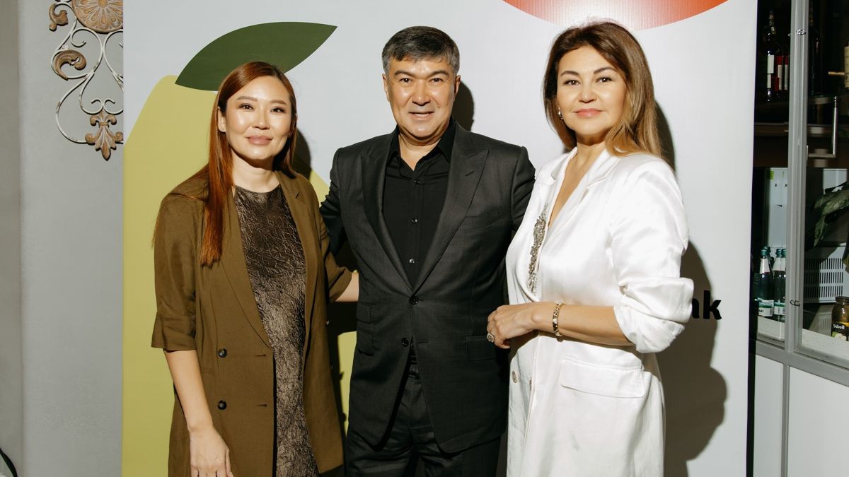 Слева направо: Людмила Тен, Рифат Абдураманов, Зульфия Хайбуллина Участники заключительного сезона Forbes Woman Brunch Club Kazakhstan стоят на фоне белый стены с цветами