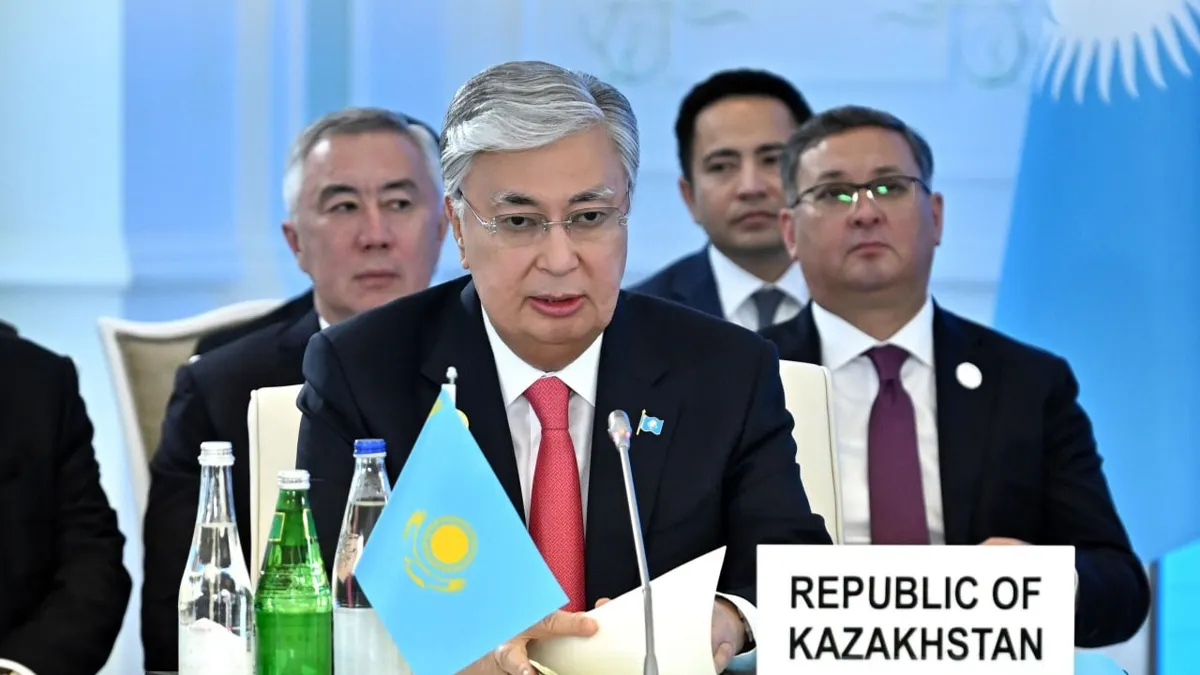 Касым-Жомарт Токаев Касым-Жомарт Токаев сидит за столом с надписью и флажком Казахстана