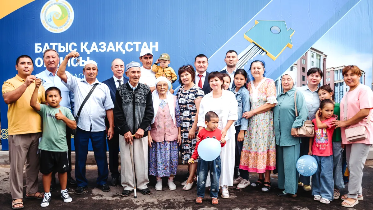 Группа людей, семьи, получают ключи от квартир от благотворителей