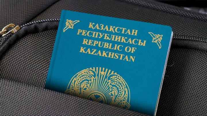 Казахстанский голубой паспорт в кармане серого рюкзака