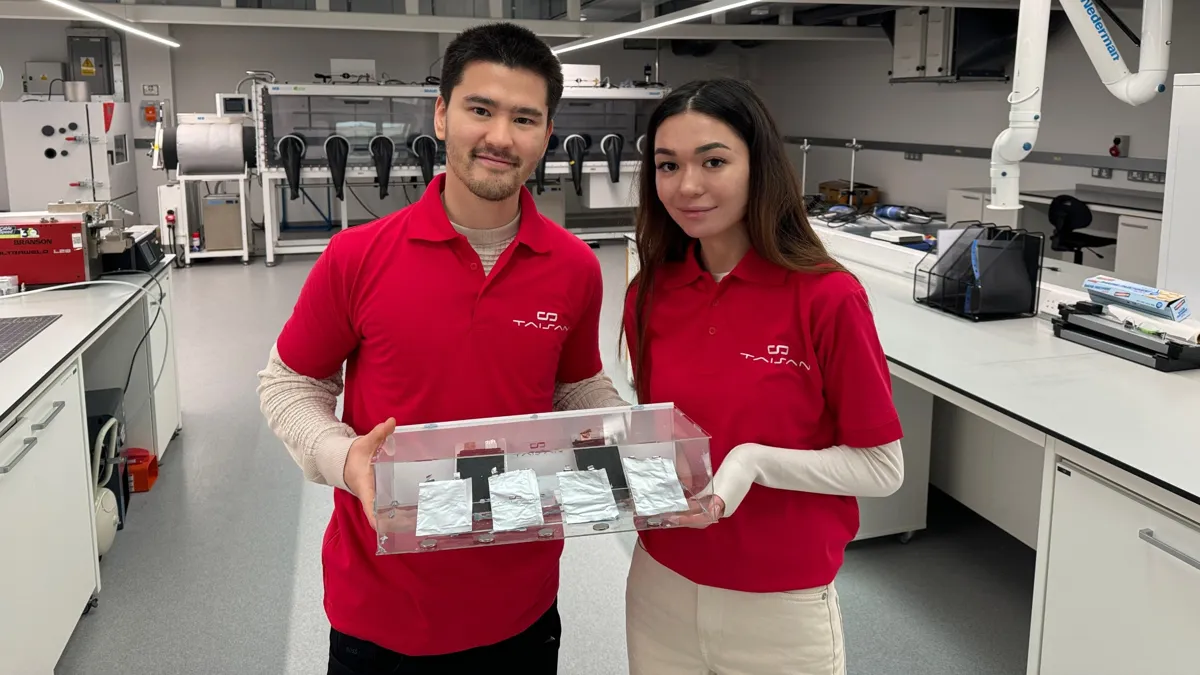Санжар Тайжан и Chief Business Officer компании TaiSan Айнур Жумашева c прототипами батареи в своей лаборатории, мужчина и женщина в красных рубашках-поло