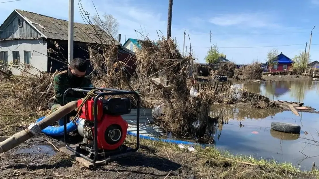 Дома затопленные от паводков, сотрудник МЧС устраняет воду