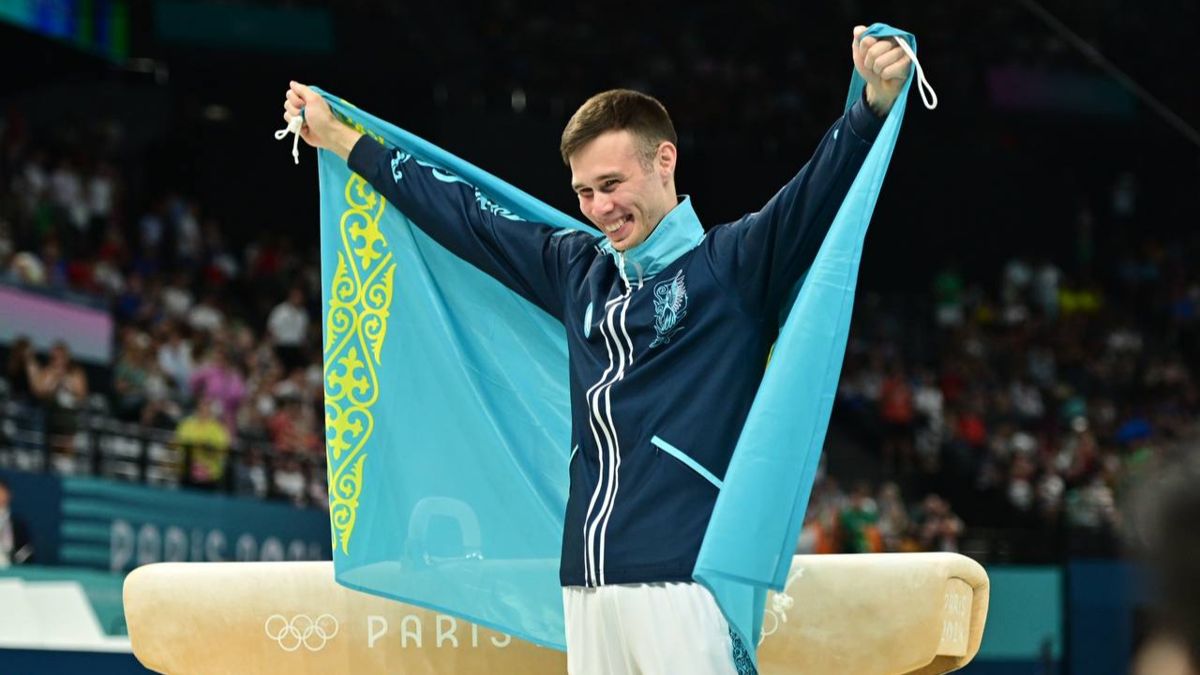 Нариман Курбанов с флагом Казахстана на награждении