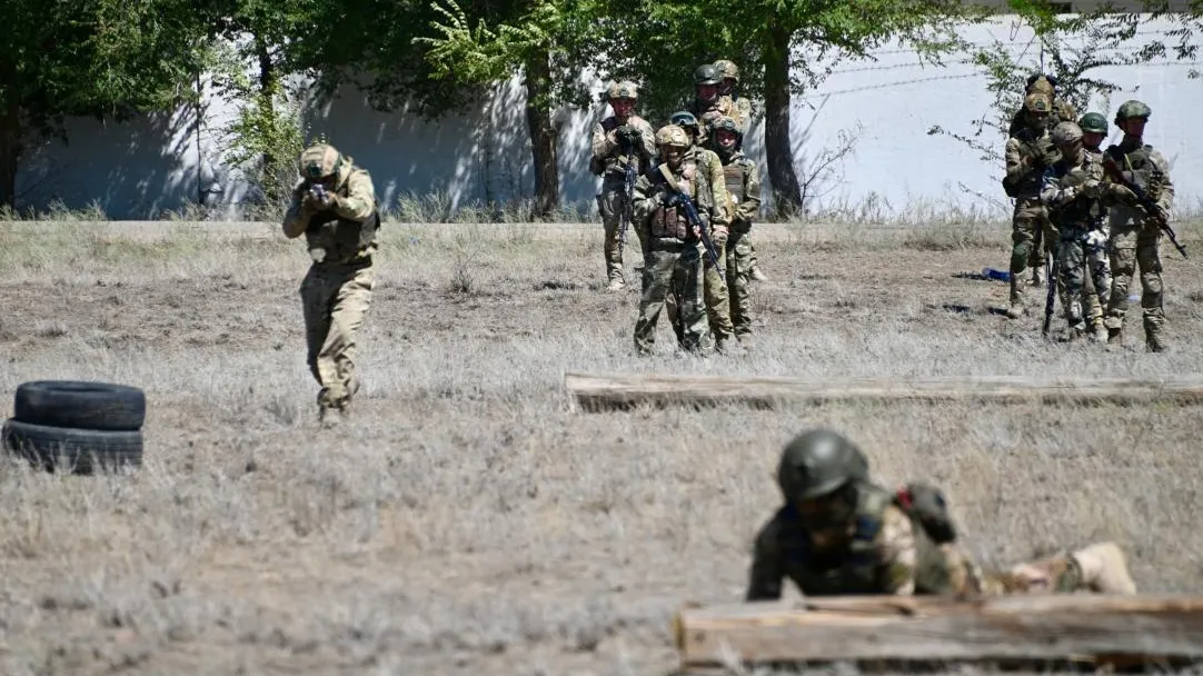 военные в камуфляже проводят учения в степи