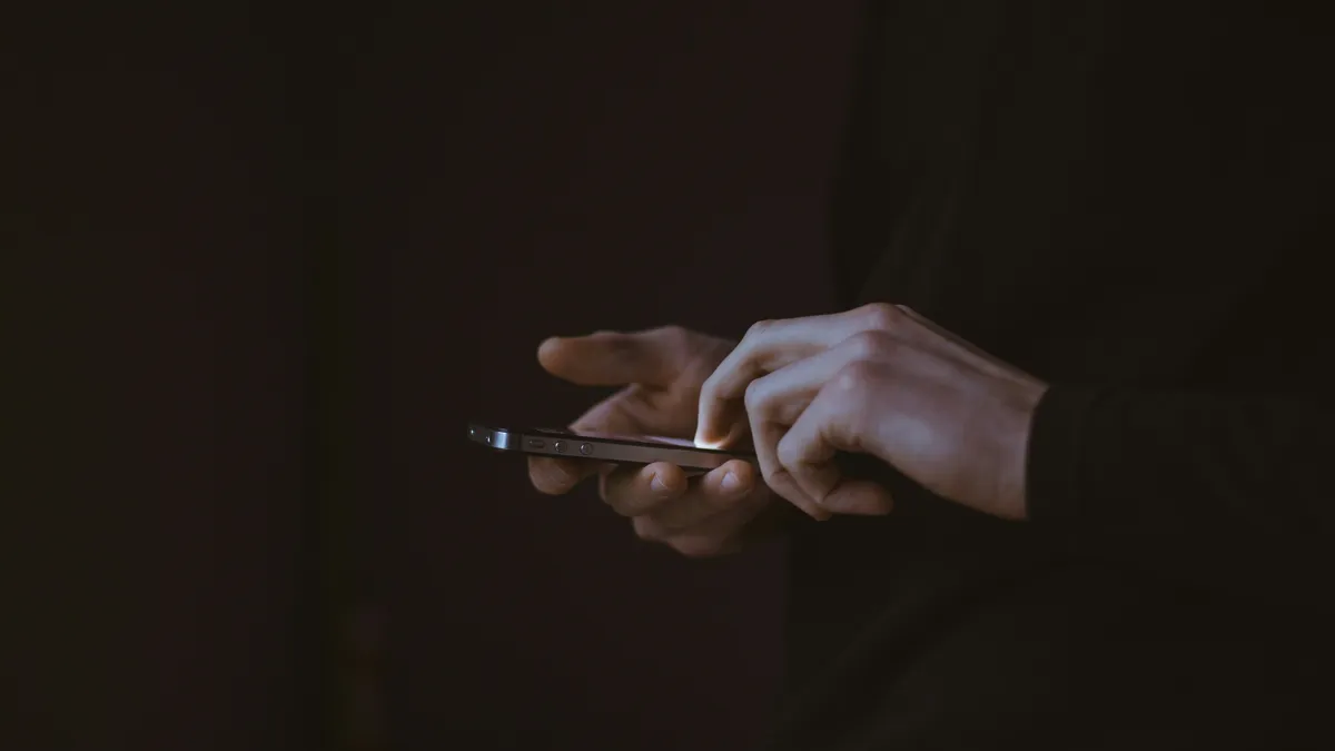 Думскроллинг — постоянный просмотр негативных новостей в социальных сетях Руки с телефоном