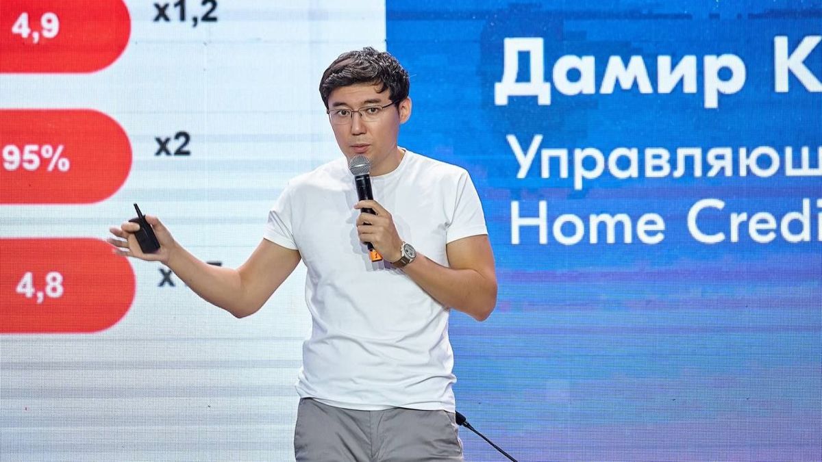 Home Credit Bank, руководитель проекта Дамир Какиев, мужчина в белой футболке на фоне экрана с надписями