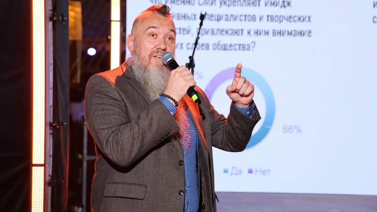 Асхат Ускембаев Асхат Ускембаев, человек с бородой в костюме на сцене с микрофоном