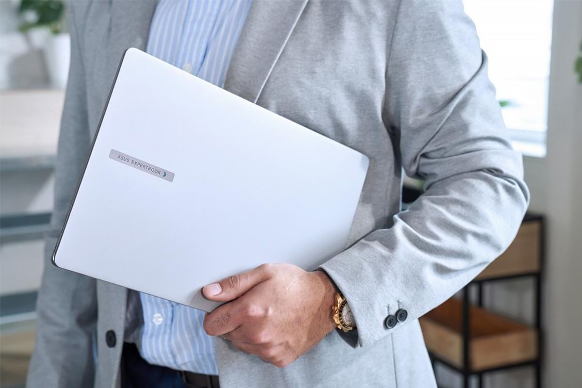 ASUS ExpertBook P5 ASUS ExpertBook P5, мужчина в светлом костюме держит нотбук