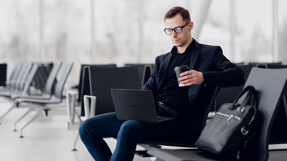 ExpertBook B5 Мужчина сидит на кресле в аэропорту с ноутбуком ExpertBook B5