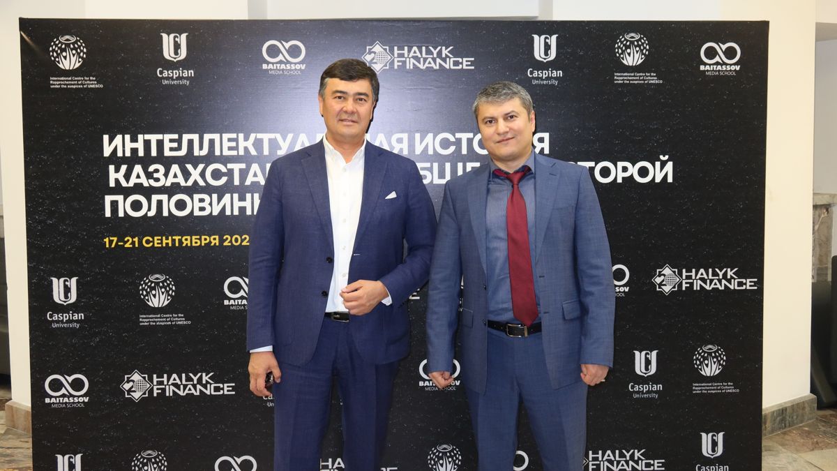 Медиапредприниматель Арманжан Байтасов и председатель правления Halyk Finance Фархад Охонов Байтасов и Фархад Охонов на фоне плаката с темой лектория