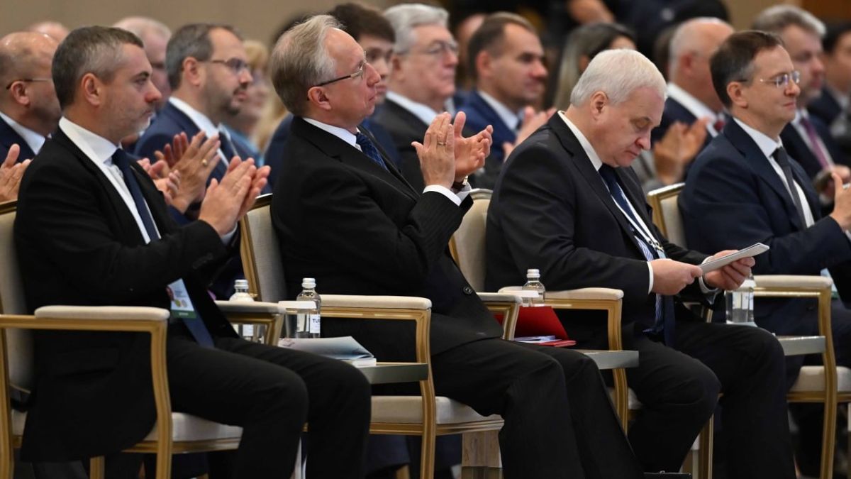 Участники конференции, мужчины в креслах аплодируют