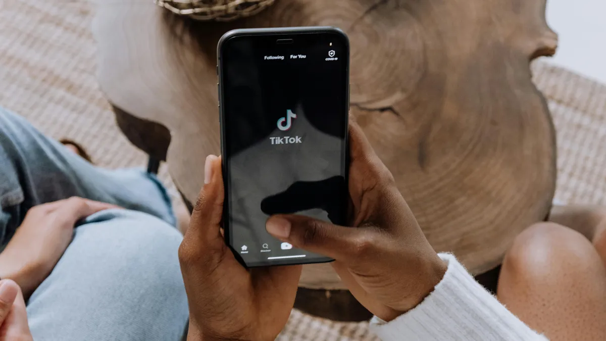 Телефон с логотипом Tik Tok в руках