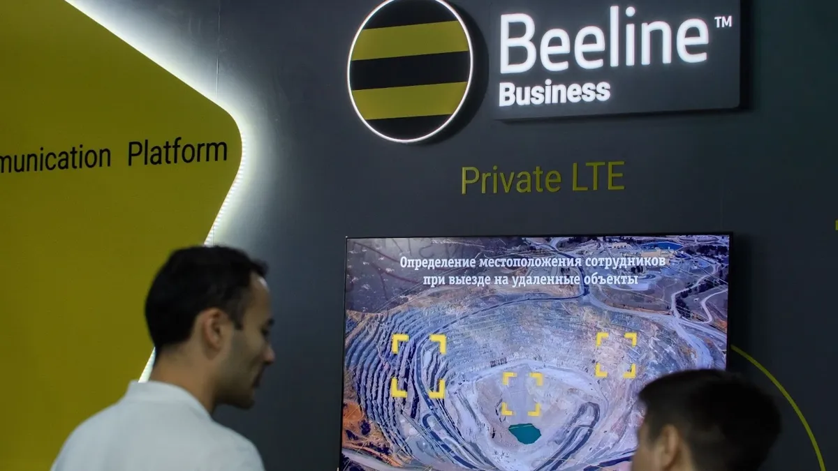 человек перед стендом с рекламой Beeline