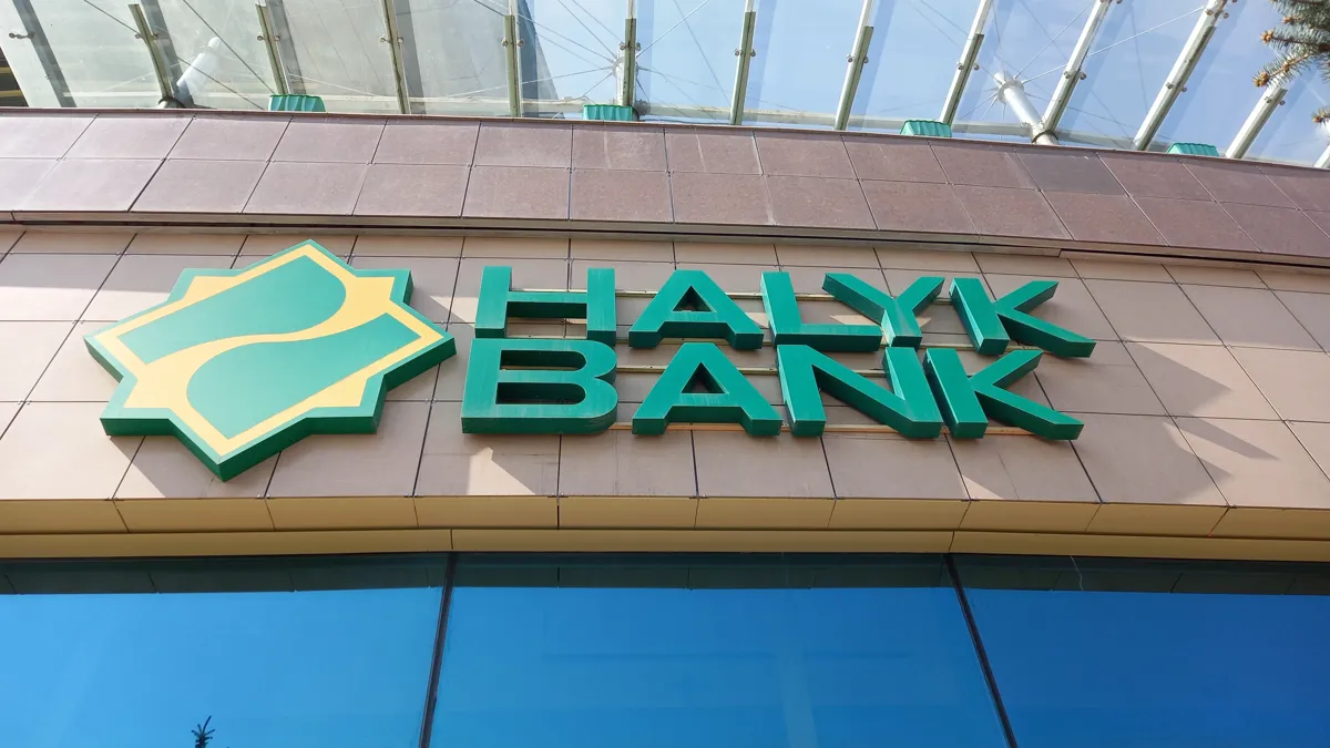 Halyk Bank выкупил свои ГДР на восьмую часть запланированной суммы Логотип Halyk Bank на фасаде здания под прозрачным козырьком, вид снизу