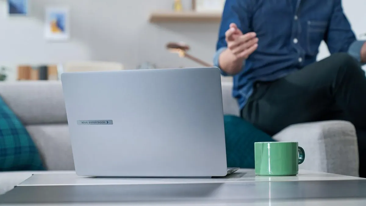 ExpertBook P5 — помощник в бизнесе ExpertBook P5, ноутбук на столе, на фоне человека, рядом зеленая чашка