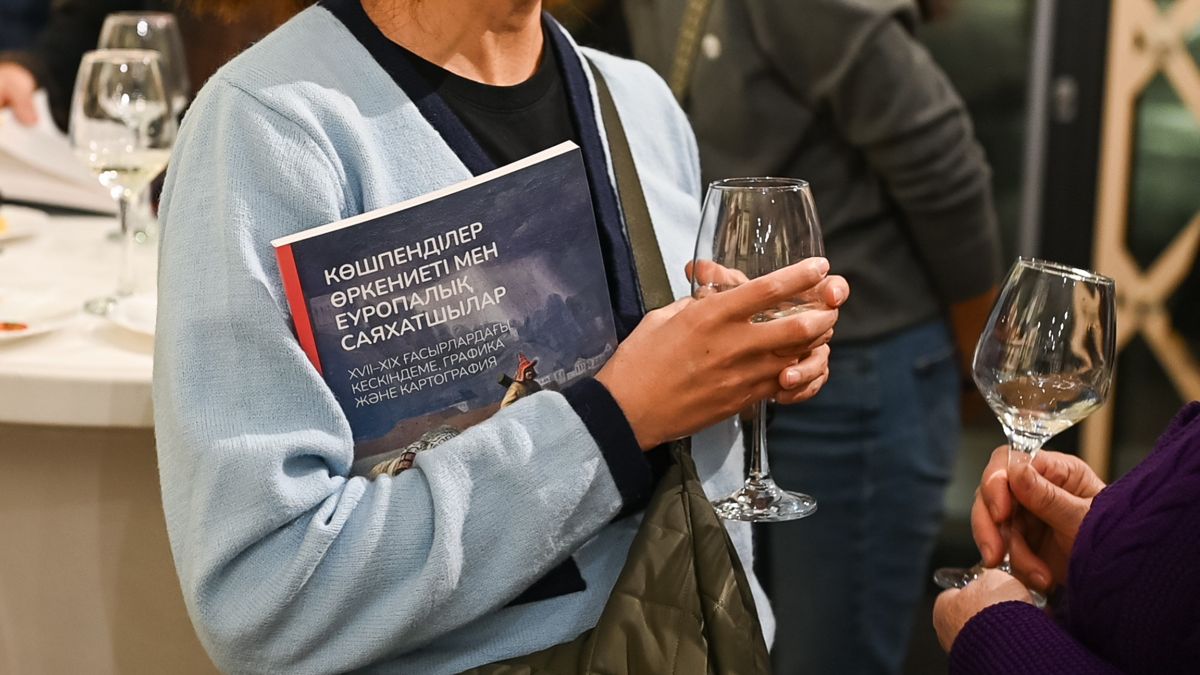 Книга «Кочевая цивилизация и европейские путешественники XVII-XIX вв. Живопись, графика и картография», книгу и бокал держат в руках 