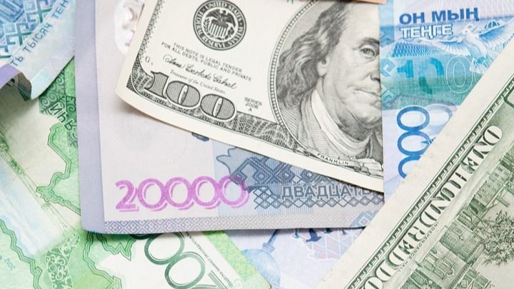 Тенге и доллары, купюры лежат, перекрывая друг друга