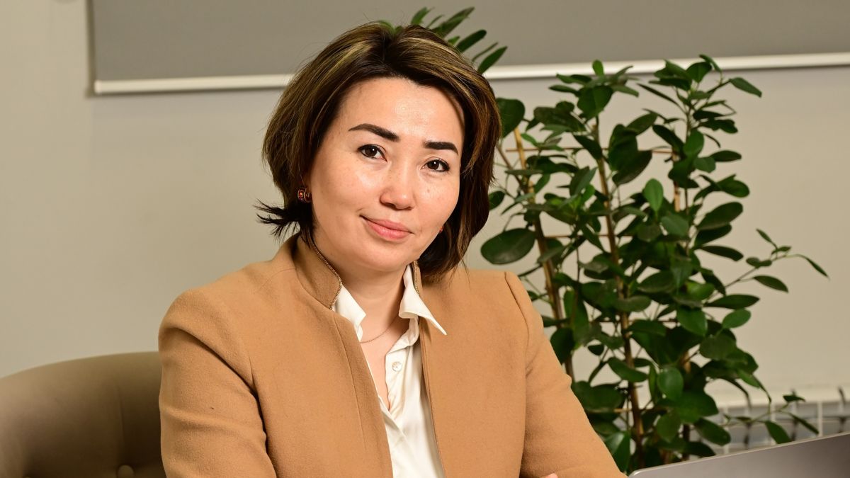 Дана Токмурзина на фоне растения