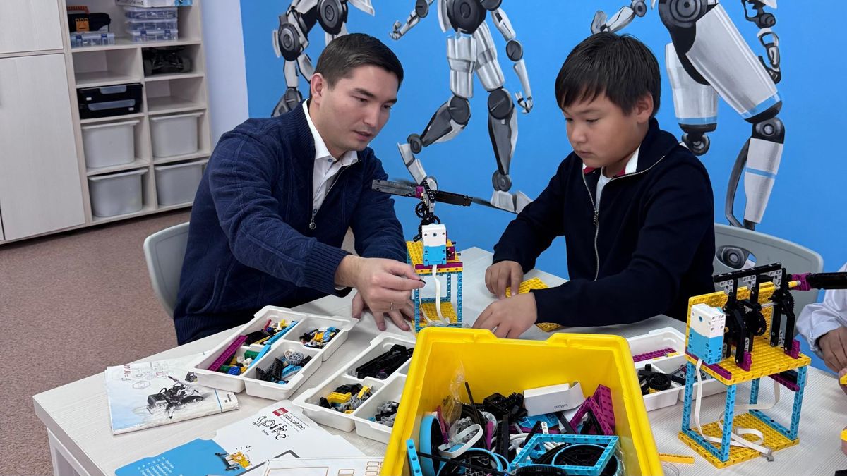 Учитель и ученик в школе занимаются с конкструктором