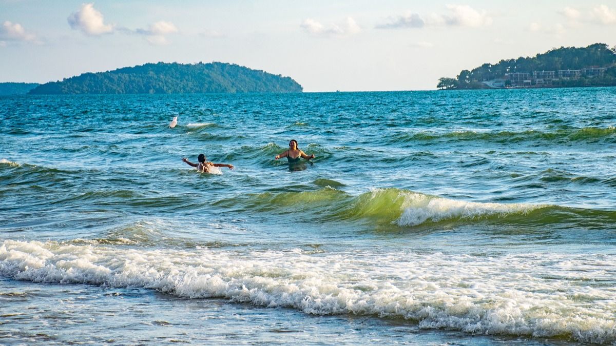 На пляже в Камбодже На пляже в Камбодже, море, волны, купающиеся люди, вид на острова