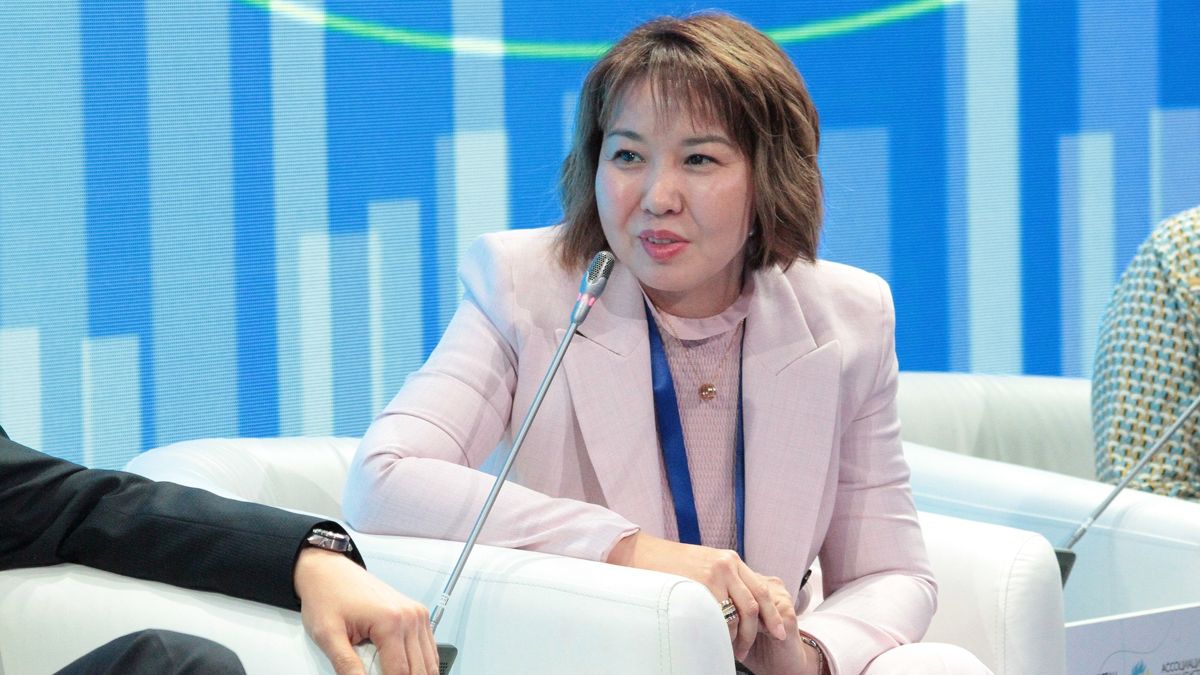 Ляззат Сатиева Ляззат Сатиева, сидит в кресле на панельной сессии мероприятия