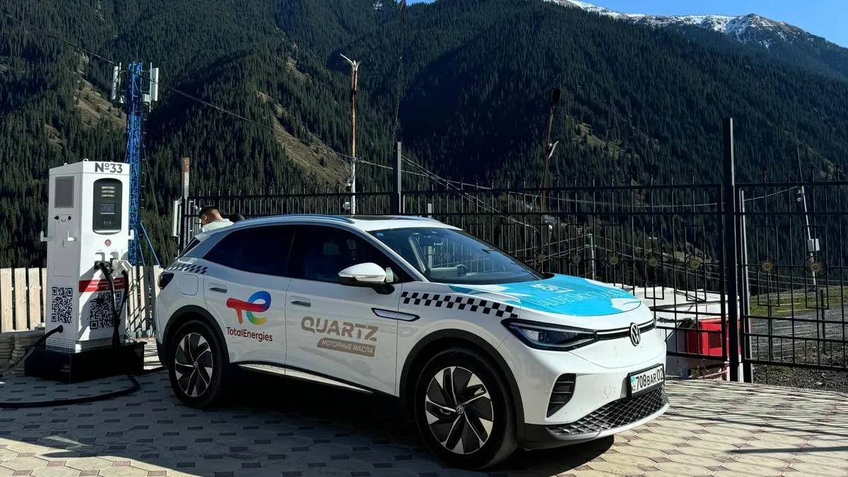 Белый кроссовер Blue Sky Taxi  на электрозарядке для автомобилей