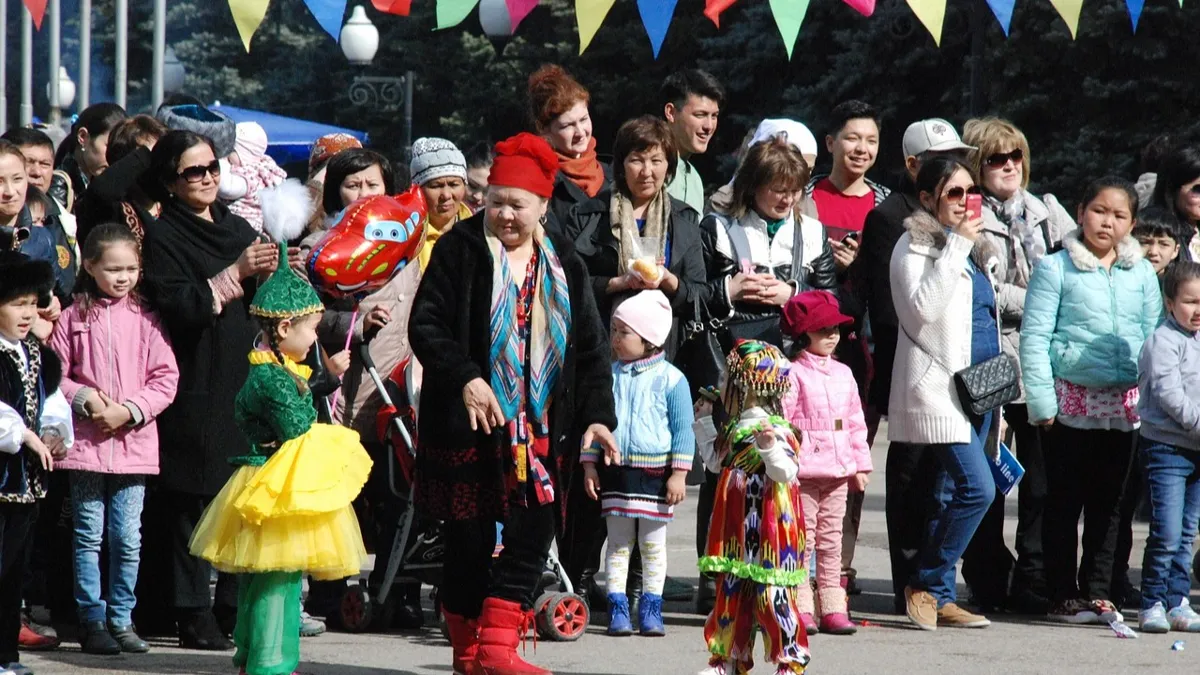 Женщины в национальной казахской одежде аплодируют