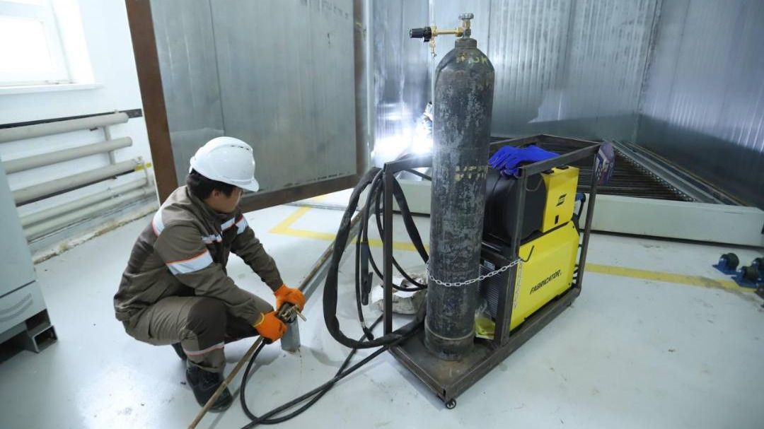 Рабочий показывает оборудование на нефтегазовом заводе в Мангистау, май 2025