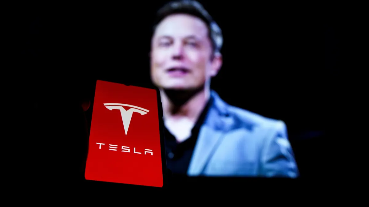 Илон Маск, логотип Tesla на фоне размытого портрета Илона Маска