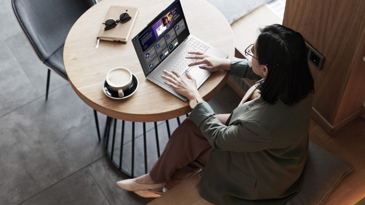 Девушка сидит на столом с ноутбуком Acer Swift Air 16, снято сверху