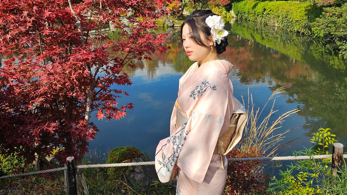 Девушка в традиционном кимоно в одном из храмов в Киото в период момидзигари